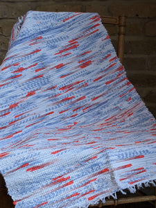 Handmade blue white and orange cotton rug on a chair