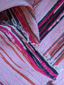 Close up details of handmade handwoven pink pattern rug