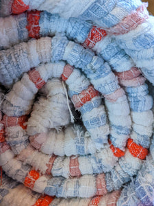 Close up details of handmade handwoven blue white orange pattern rug