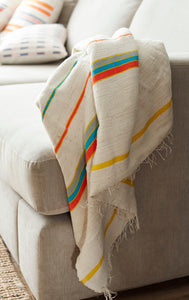 Small handmade multicoloured cotton blanket on a sofa