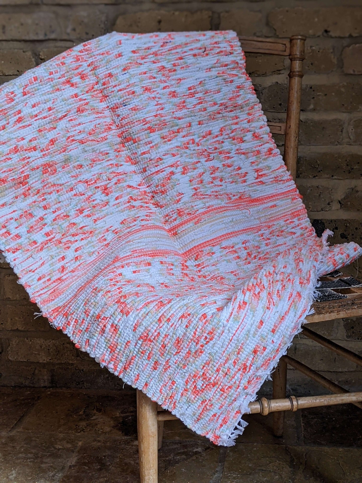 Handwoven Orange white pattern cotton rug on chair