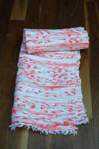 Handwoven Orange white pattern cotton rug rolled up