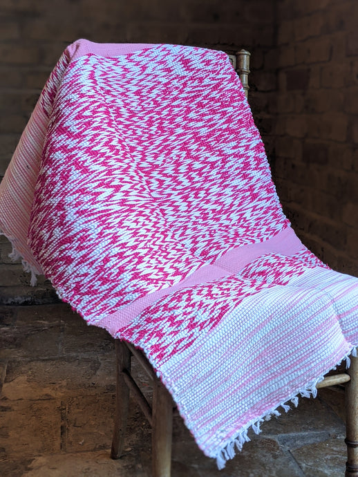 Handmade, woven pink and white rug