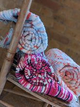 Load image into Gallery viewer, Three rolled up handmade handwoven rugs on a chair